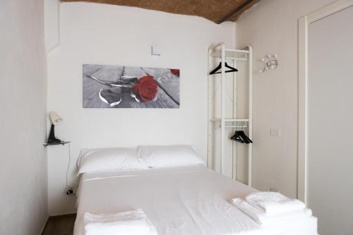 een slaapkamer met een wit bed en een schilderij aan de muur bij Villa Viani in Soliera