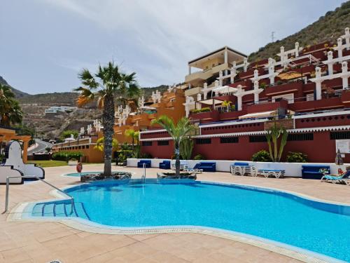 a large swimming pool in front of a building at Cozy 2 Bedroom Apartment in Costa Adeje in Adeje