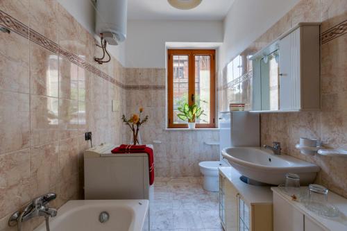 een badkamer met een bad, een wastafel en een toilet bij Casa Vacanze Maria in Bosa