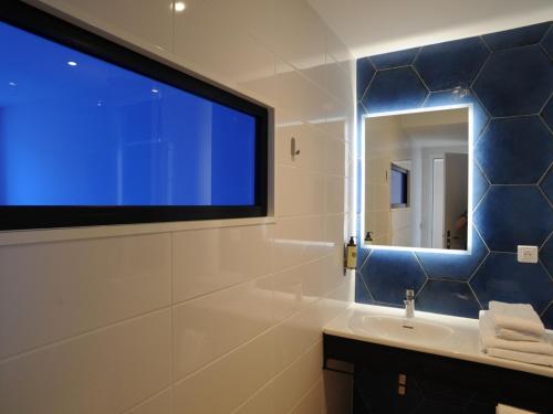 a bathroom with a sink and a large window at Hôtel Les Mouettes in La Couarde-sur-Mer