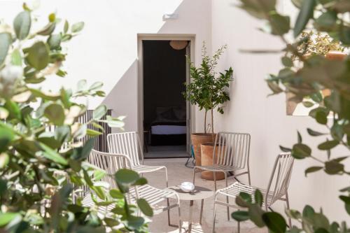 a patio with chairs and a table with a potted plant at Palazzo Tafuri Boutique Hotel in Nardò