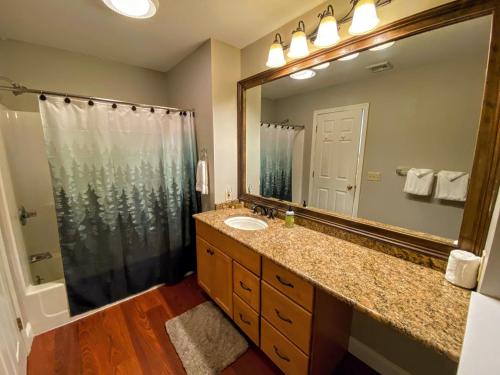 La salle de bains est pourvue d'un lavabo et d'un grand miroir. dans l'établissement F5 Renovated home on golf course in Bretton Woods AC, à Carroll