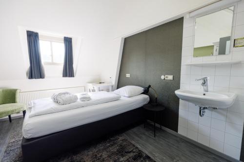 a bedroom with a bed with a sink and a mirror at B&B Landgoed De Grote Beek in Eindhoven