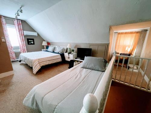 1 dormitorio con 2 camas y TV. en Executive Suite Loft - Harvard Allston Campus, en Boston