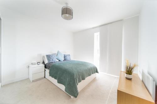 a white bedroom with a bed and a desk at LiveStay-Modern One Bed Apartment in Private Building in Luton