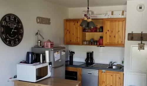 una cucina con frigorifero e forno a microonde di Au Centre de la station de ski de Valfréjus - appartement 4-6 personnes a Valfréjus