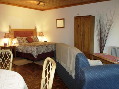 1 dormitorio con 1 cama, 1 mesa y 1 silla en Tweed Valley Lodge, en Bridgetown