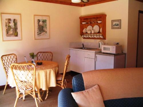 een keuken met een tafel en stoelen in een kamer bij Tweed Valley Lodge in Bridgetown