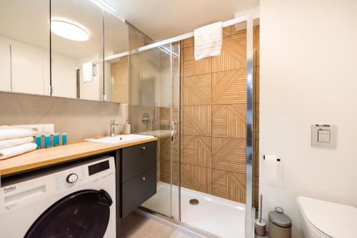 a bathroom with a washing machine and a shower at Powiśle Chic Apartment in Warsaw