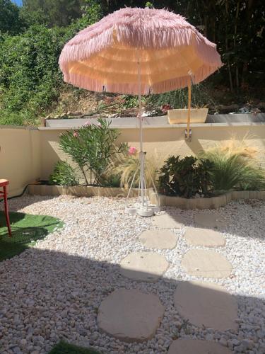 an umbrella sitting on top of a gravel patio at Mazet de vacances residence l espai in Saint-Martin-de-Brômes