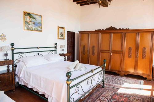 ein Schlafzimmer mit einem großen Bett und einem Holzschrank in der Unterkunft Il Libro- Family Holiday in Tuscany in Santa Maria a Monte