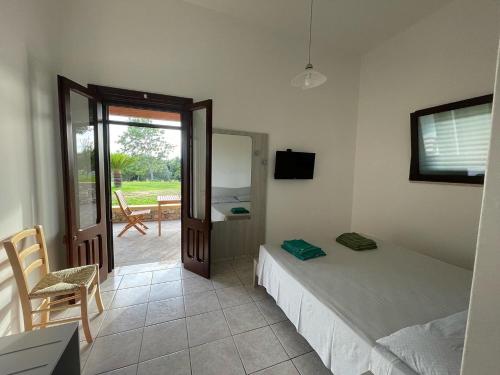 a bedroom with two beds and a door to a patio at Agriturismo Tenuta Pozzello in Torre dell'Orso