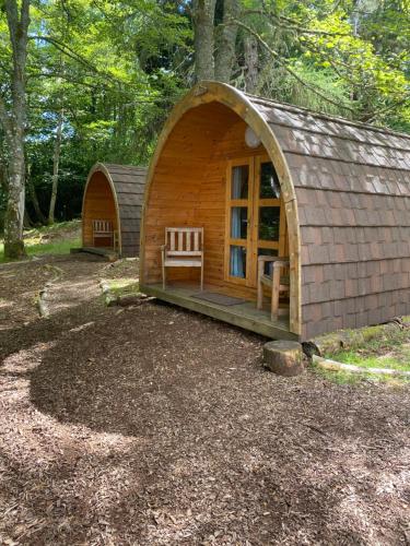 a small cabin in the woods with a bench in it at Fairburn Activity Centre in Contin