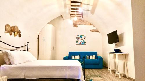 1 dormitorio con 1 cama y 1 silla azul en Antiche Mura Apartments"Nido di Puglia" monovano, en Turi