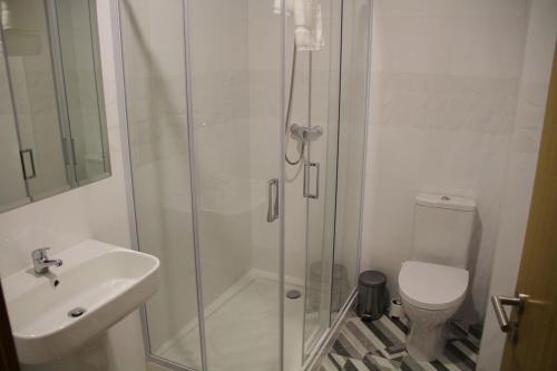 a bathroom with a shower and a sink and a toilet at JP VILLAGE Hotel in Nelas