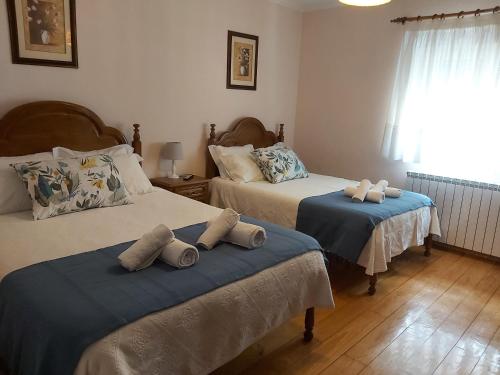 1 dormitorio con 2 camas y toallas. en Encosta da Serra, en Sabugueiro