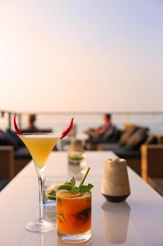 two cocktails sitting on a table in a room at Cape Sienna Phuket Gourmet Hotel & Villas - SHA Extra Plus in Kamala Beach