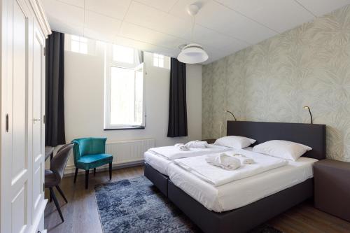 a bedroom with a large bed and a blue chair at B&B Landgoed De Grote Beek in Eindhoven