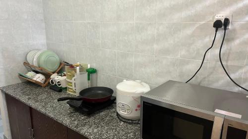a kitchen counter with a microwave and a counter top at Condo D 'Savoy 3 Room in Kampong Alor Gajah