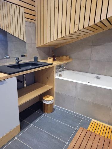une salle de bain avec un lavabo et une baignoire dans l'établissement Chalet Spa Fora Pista, à Bolquère-Pyrénées 2000
