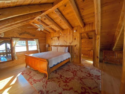 1 dormitorio con 1 cama en una cabaña de madera en SI INCREDIBLE VIEWS from this log cabin with large deck huge yard fire pit hot tub en Dalton