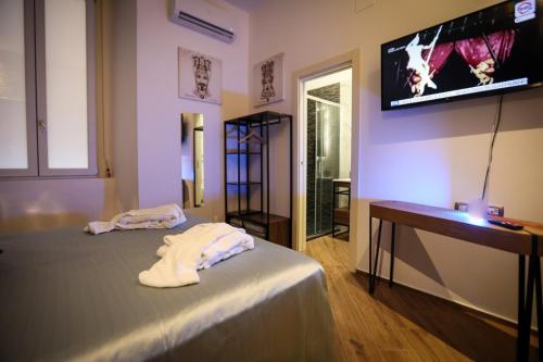 a bedroom with a bed and a flat screen tv at PETRAMARE Charming House in Salerno