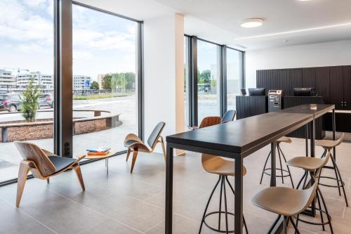 a dining room with a black table and chairs at B&B HOTEL Famalicão in Vila Nova de Famalicão