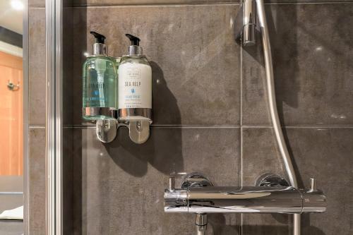 a bathroom with two shampoo bottles on a wall at The Duke on The Test in Romsey