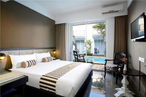 Una habitación de hotel con una cama grande y un balcón. en 7 Bidadari Hotel Seminyak, en Seminyak