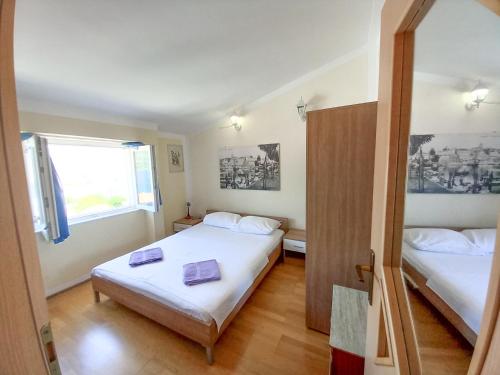 Habitación pequeña con 2 camas y ventana en Apartment Bella Vista en Korčula