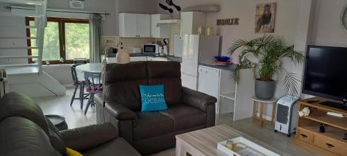 a living room with a couch and a kitchen at Chez Stéphane in Rochefort