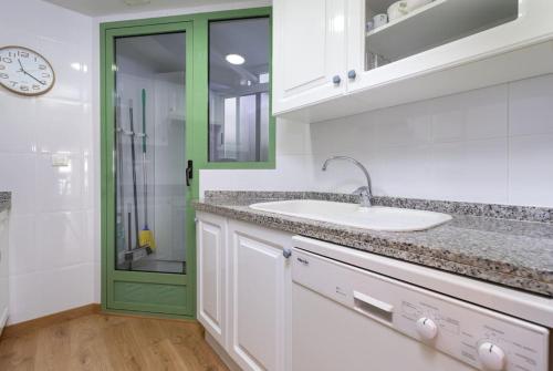 baño con lavabo y puerta verde en ApartUP Patacona Beach I, en Valencia