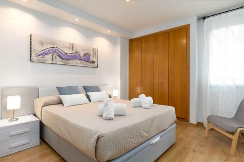 バレンシアにあるApartUP Patacona Beach Iのベッドルーム1室(ベッド1台、椅子付)