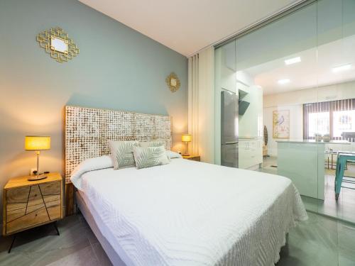 a bedroom with a large white bed and a kitchen at Cubo's Boutique Urban Deluxe in Alhaurín el Grande