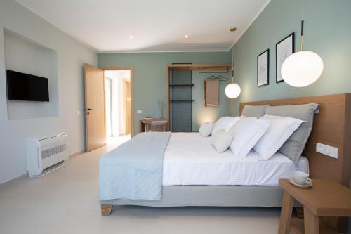 a bedroom with a large white bed and a tv at villa-agrielia in Nikiana