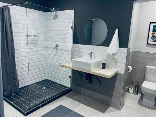 ein Bad mit einem Waschbecken und einer Dusche in der Unterkunft 46 on Allcock Guest Apartment & Luxury Room in Pretoria