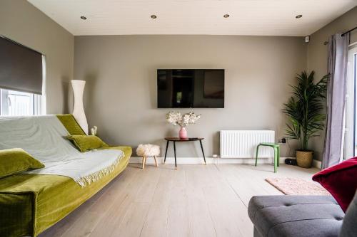 a bedroom with a bed and a table and a couch at Holmestead Cottage in Tyrella