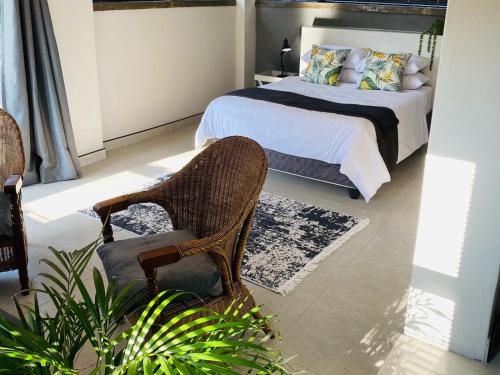 a bedroom with a bed and a chair at 46 on Allcock Guest Apartment & Luxury Room in Pretoria