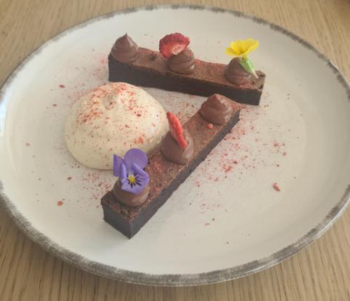 a piece of chocolate cake with a ice cream on a plate at Rengő Panzió in Taksony