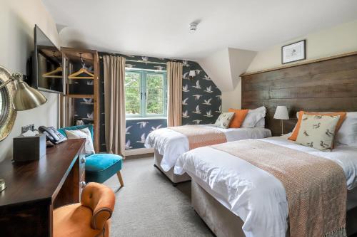 a hotel room with two beds and a desk at The Duke on The Test in Romsey