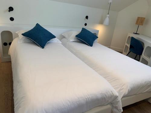 een slaapkamer met 2 bedden en blauwe kussens bij Grand Hôtel de Bretagne in Le Palais