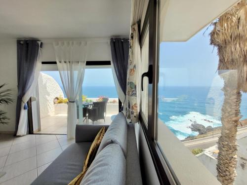 - un salon avec un canapé et une vue sur l'océan dans l'établissement Blue Coast Bellavista, à Puerto de la Cruz