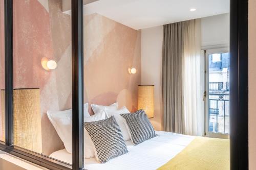 um quarto com uma janela e uma cama com almofadas em Yuna Les Halles - Serviced Apartments em Paris