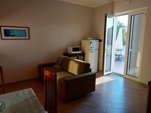 a living room with a couch and a refrigerator at Il Poggio degli Antichi Sapori - Residence in Paternopoli