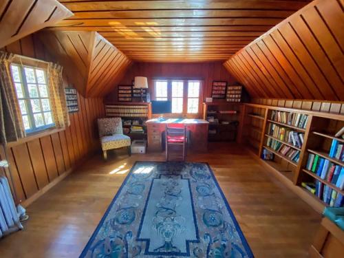 an attic room with a library with a rug on the floor at WOW New Spectacular Franconia Home - history - views - fire pit - hot tub - pool - grandeur - MUST SEE in Franconia
