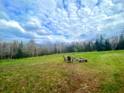 a park with two benches and a picnic table in a field at WOW New Spectacular Franconia Home - history - views - fire pit - hot tub - pool - grandeur - MUST SEE in Franconia