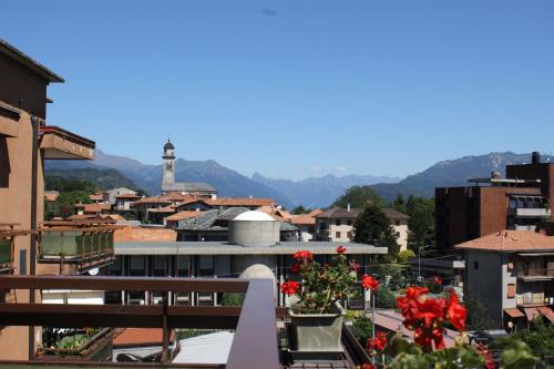 un balcone con fiori rossi e vista sulla città di APPARTAMENTO AMPIO E LUMINOSO LAGO D'ORTA a San Maurizio dʼOpaglio