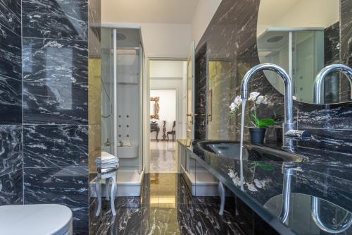 ein schwarzes Bad mit einem Waschbecken und einem WC in der Unterkunft Ginevra Luxury New Classic Apartment close Vatican in Rom