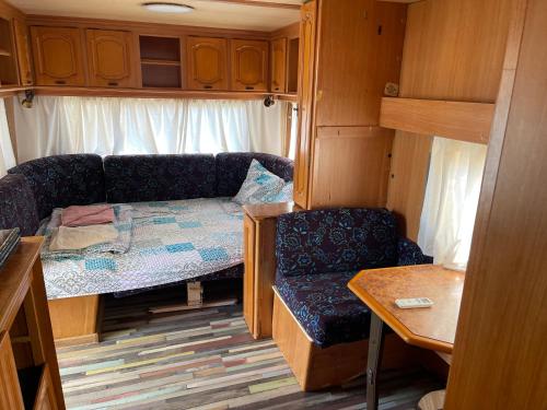 ein kleines Zimmer mit einem Sofa und einem Stuhl in einem Wohnwagen in der Unterkunft SEA CARAVAN ON THE BEACH in Kiten