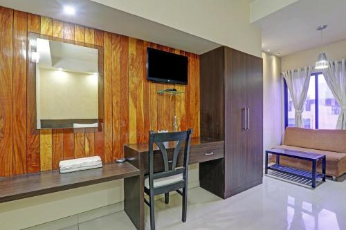 Zimmer mit einem Schreibtisch, einem Spiegel und einem Sofa in der Unterkunft SHELTER HOTEL in Lucknow